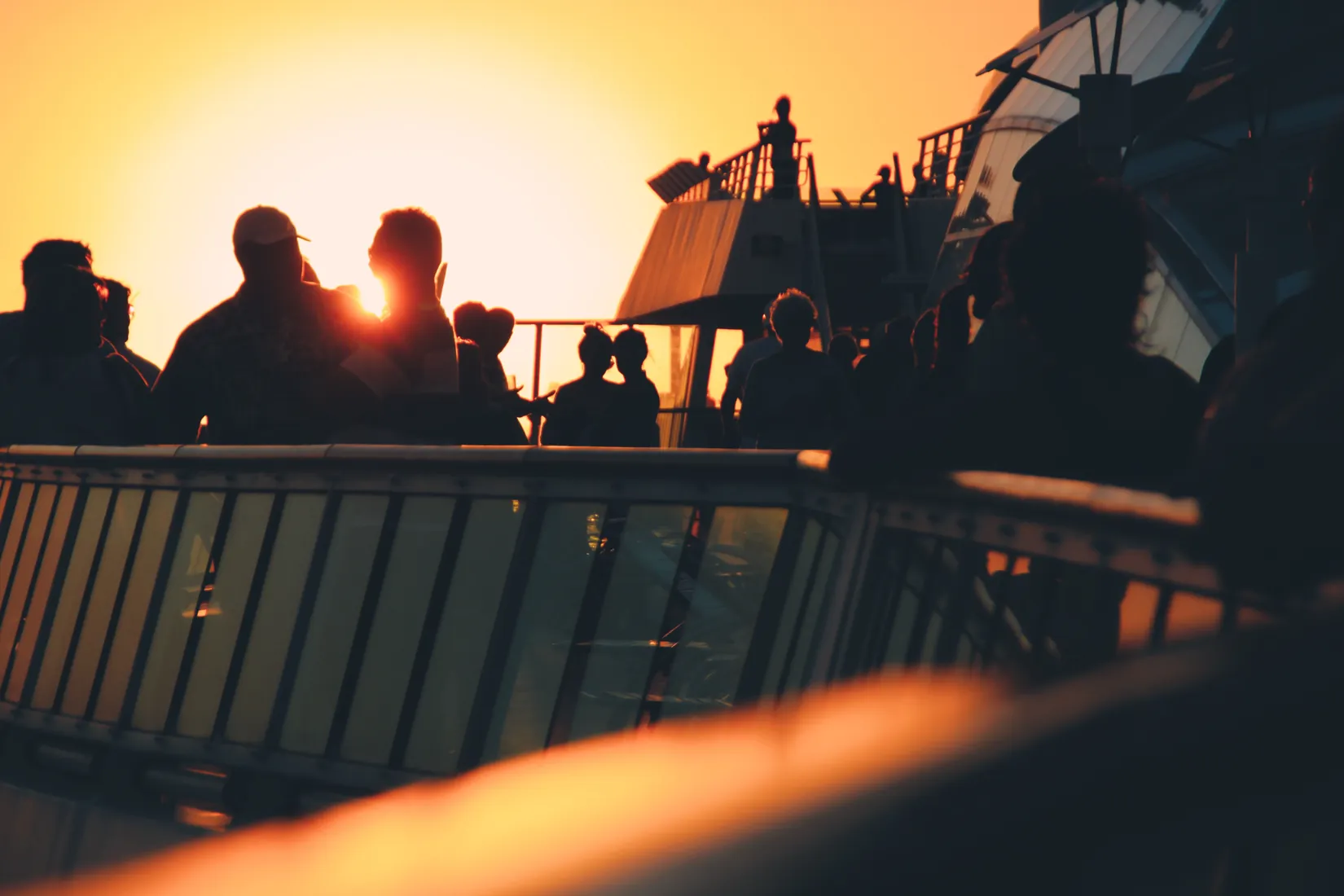 Guests on deck as the ship sails at golden hour